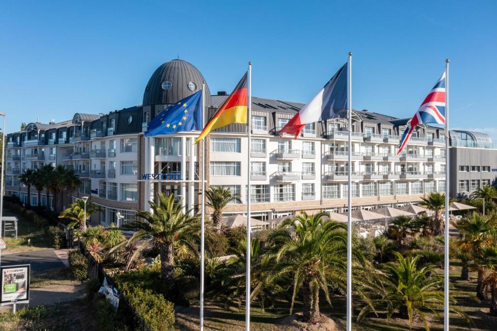 a hotel with flags in front of it at Westotel Le Pouliguen in Le Pouliguen