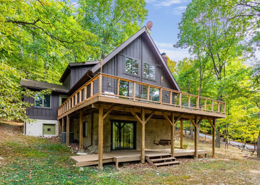 a large house with a gambrel roof and a deck at Hot Tub, Private Lake, & Huge Deck at Chalet Cabin in Berkeley Springs