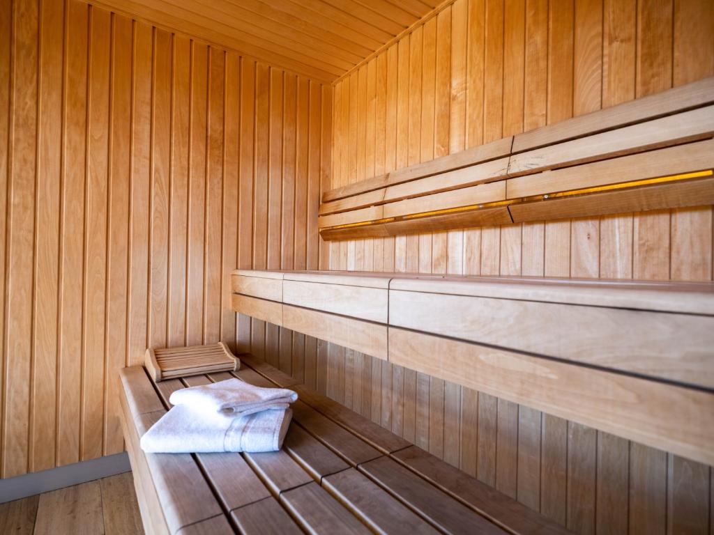 a sauna with wooden walls and a bench in it at Westotel Le Pouliguen in Le Pouliguen