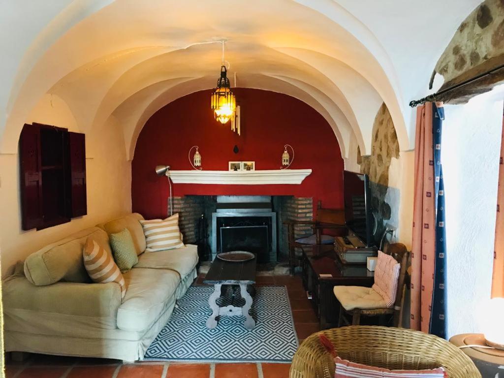 sala de estar con sofá y chimenea en Casa Bibiana, en Posadilla