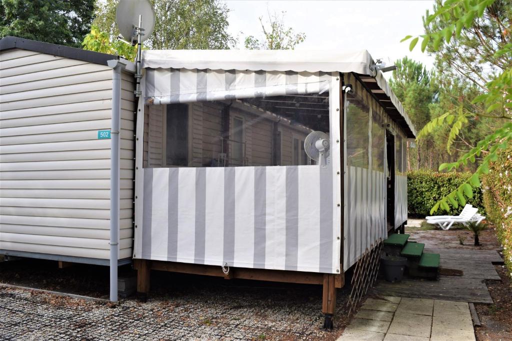 a shed with a white roof on a patio at Spacieux Mobil-home N°502 - 2 chambres - dans Camping 4 * in Gastes