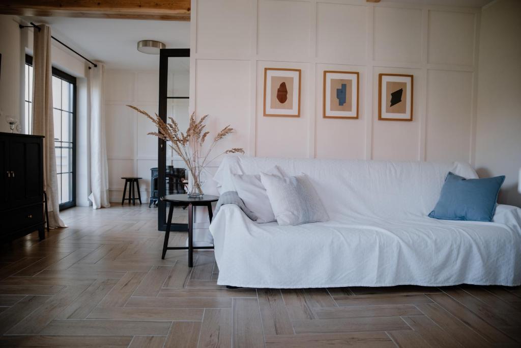 un sofá blanco sentado en una sala de estar en Agroturystyka u Marleny, en Skorzenno
