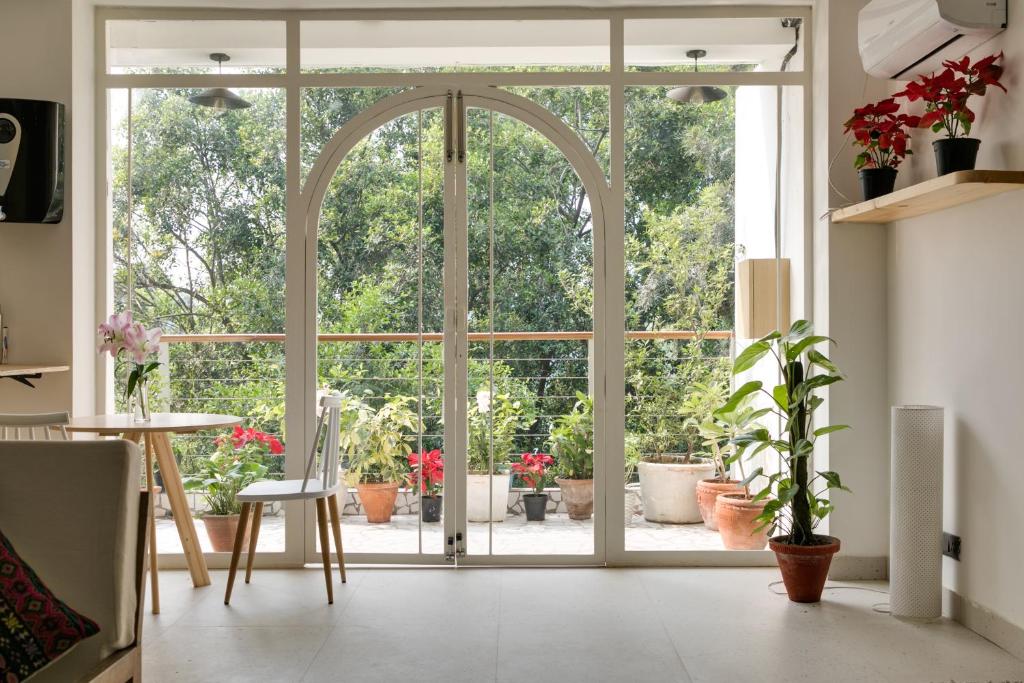 d'une porte ouverte sur une terrasse agrémentée de plantes en pot. dans l'établissement Vaara, à New Delhi