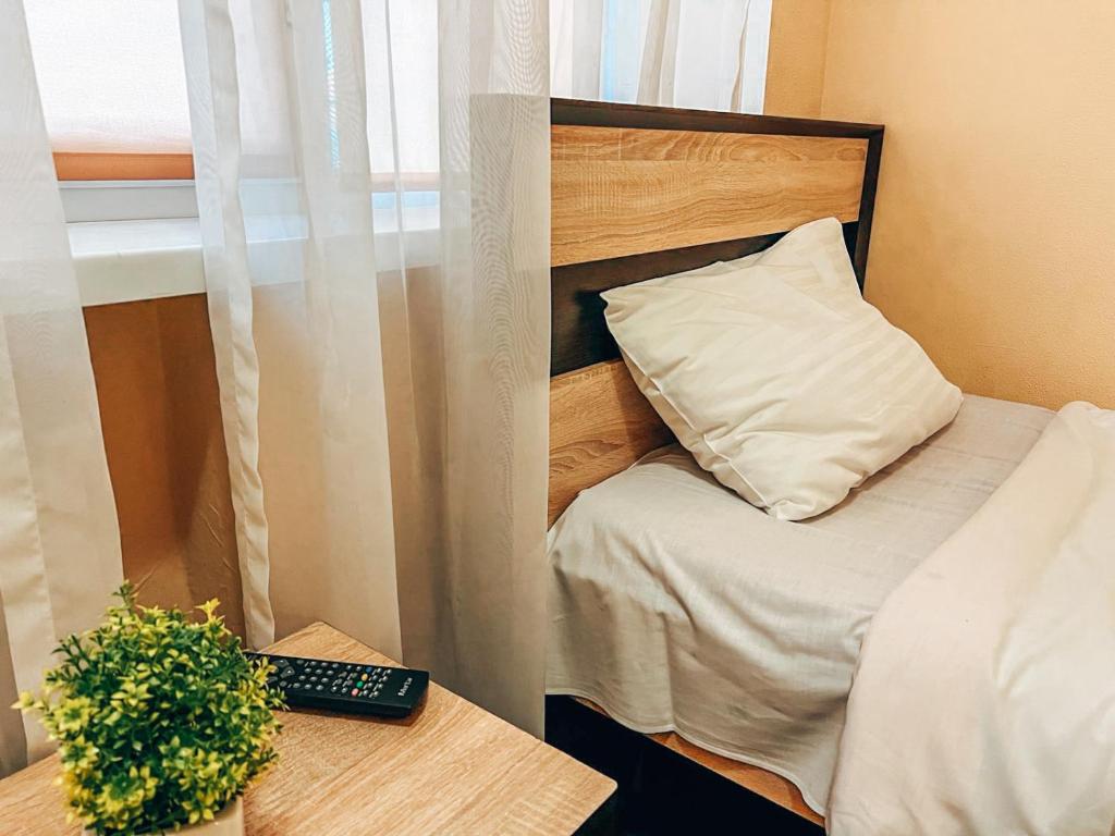 a small room with a bed with a pillow and a desk at Guest House near Railway Station in Kyiv