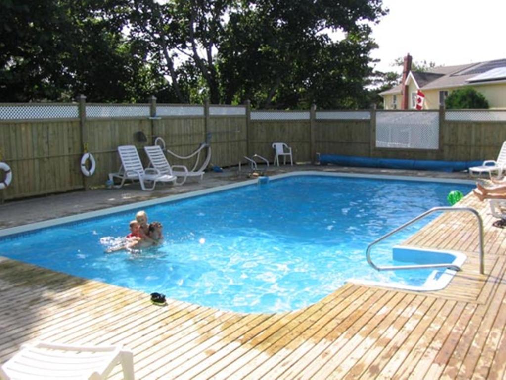 a child swimming in a swimming pool at Shining Waters - Ingleside Cottages in Cavendish