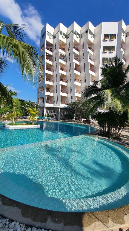 a large swimming pool in front of a large building at Double Superior Condo Rayong with seaview - 7th floor free wifi in Rayong