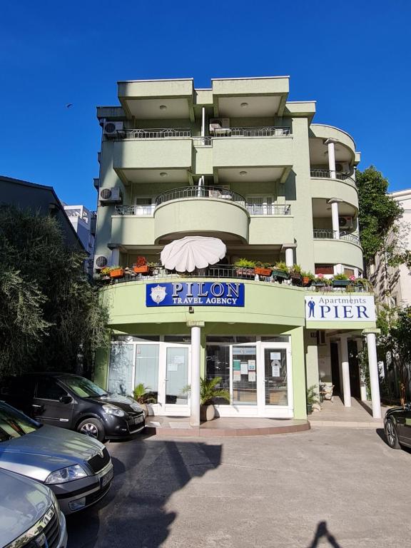 a building with a parking lot in front of it at Apartments Pier in Budva