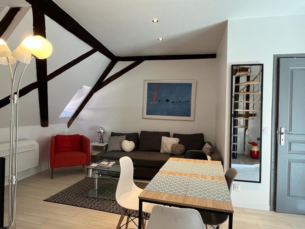un soggiorno con divano e tavolo di La Mariana - Old Town Cosy Apartments a Colmar