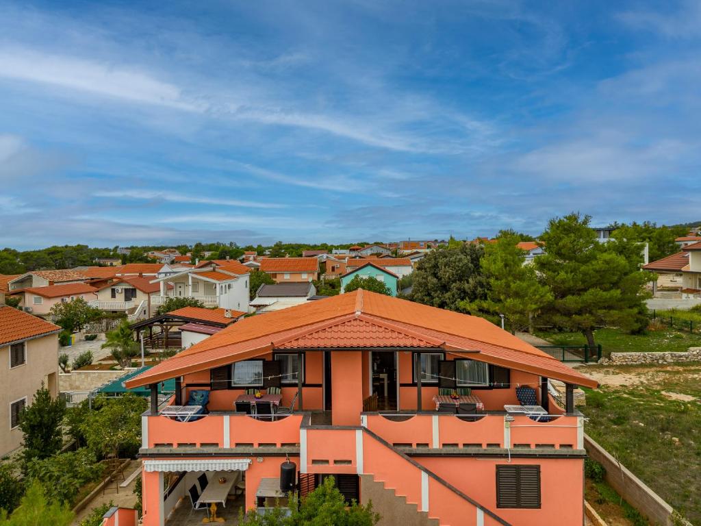 dom z pomarańczowym dachem w mieście w obiekcie APARTMANI ZLATA w mieście Vir