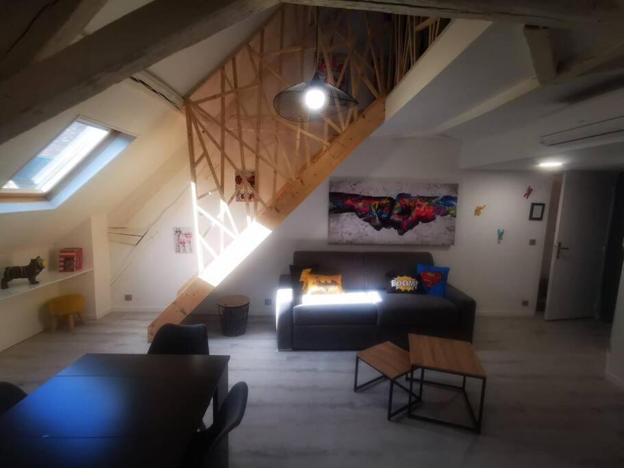 uma sala de estar com um sofá preto num sótão em Au numéro 6 Le Fun em Châteauroux
