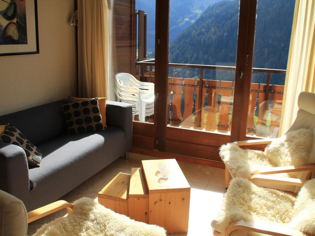 ein Wohnzimmer mit einem Sofa und einem Balkon in der Unterkunft Appartement Châtel, 2 pièces, 5 personnes - FR-1-200-220 in Châtel