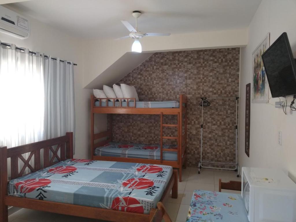 a bedroom with two bunk beds in a room at Quitinetes Canto Verde Caraguá in Caraguatatuba