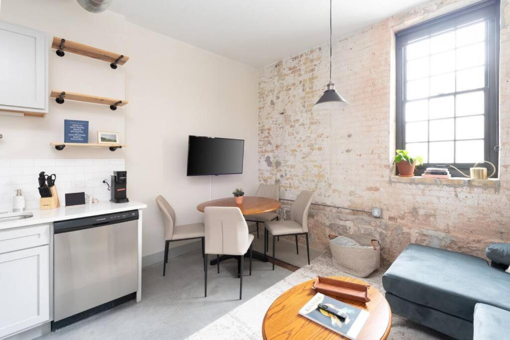 a kitchen and living room with a table and a couch at Brewery District 2-Story 2BR Apt Near Fiserv with Rooftop, Gym, and Parking in Milwaukee