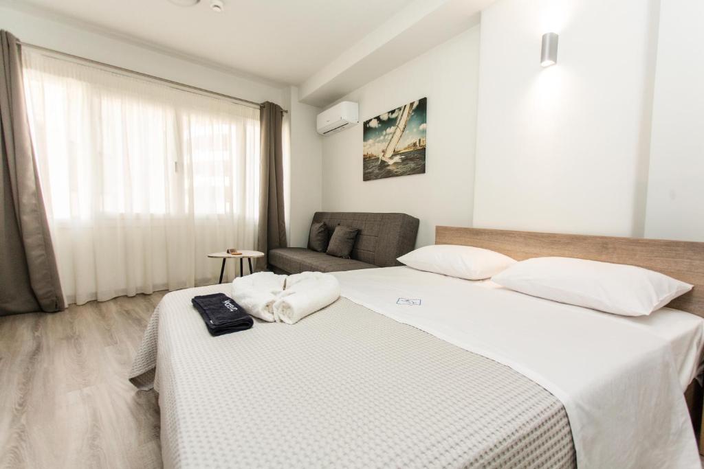 Habitación de hotel con 2 camas y sofá en John Central Suites en Tesalónica