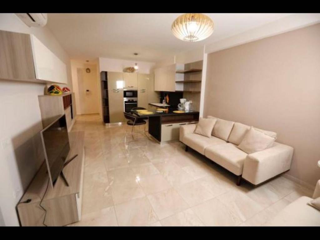 a living room with a couch and a kitchen at Beachfront Sion Sarande Apartment 1 in Sarandë