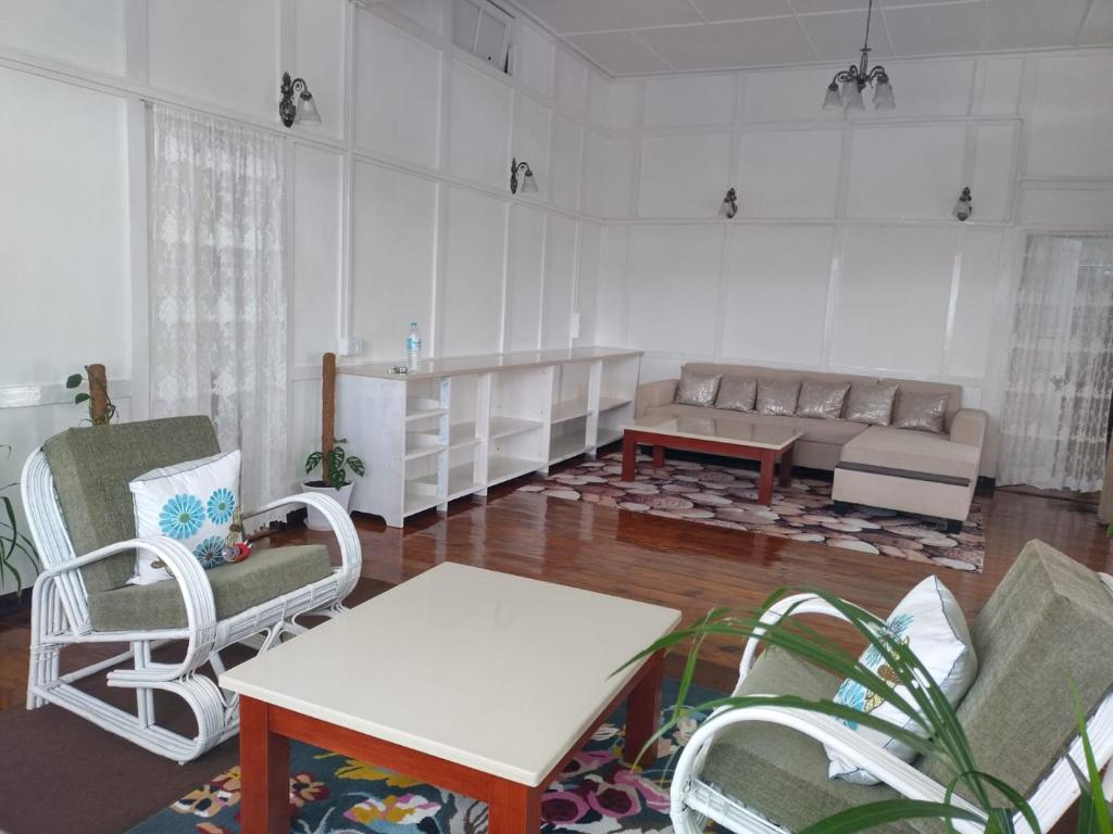 - un salon avec un canapé et une table dans l'établissement Casa Encanto Homestay, à Shillong