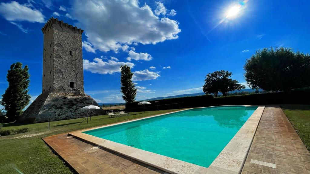 een zwembad voor een gebouw met een toren bij Spello By The Pool - Sleeps 11 - fabulous villa pool All exclusively yours in Limiti