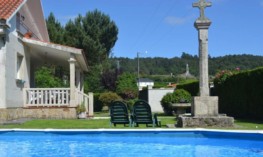 a pool with two chairs and a cross next to a house at Casa Olivar El Mandarino 