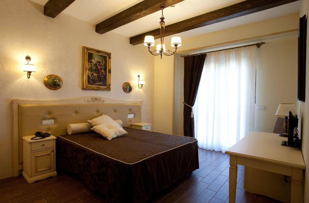 - une chambre avec un grand lit et une fenêtre dans l'établissement Hotel Villa Clementina, à Scafati