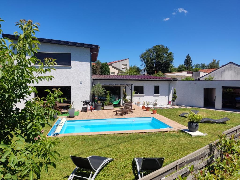 a backyard with a swimming pool and a house at Doubs repère in Montferrand-le-Château