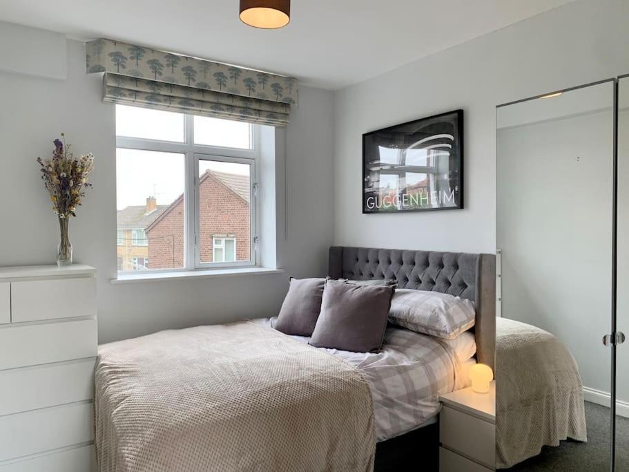 a bedroom with a bed and a window at Unique Central Newark Double-Height Apartment in Newark-on-Trent