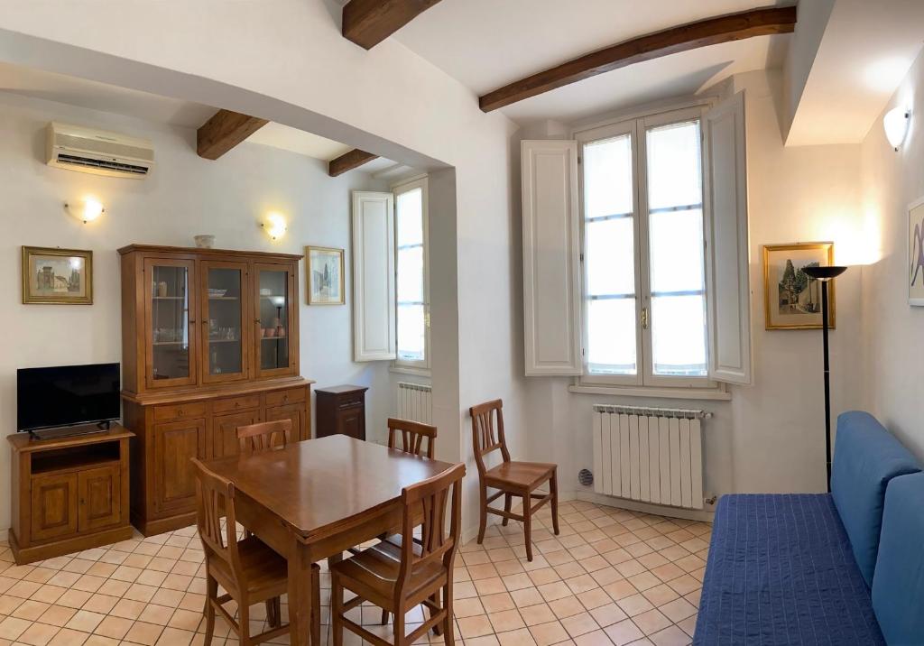 un soggiorno con tavolo e divano blu di Appartamento caratteristico Santa Maria Novella a Firenze
