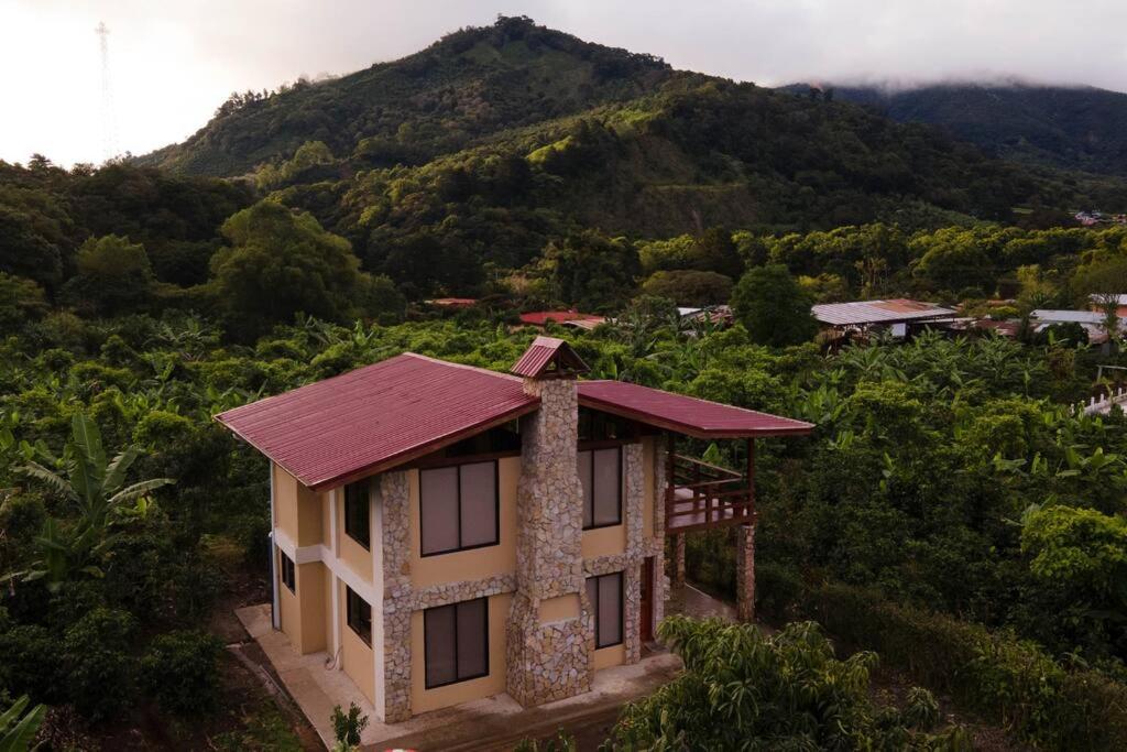 uma pequena casa com uma montanha ao fundo em Juliet's Coffee House em Higueronal