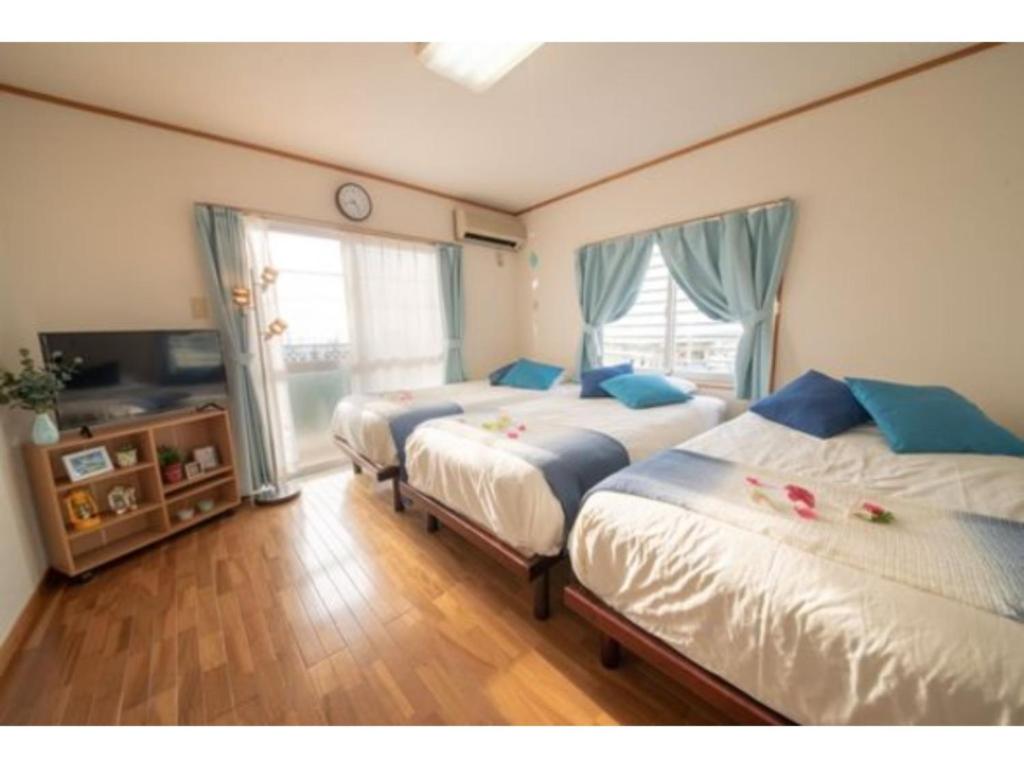 a bedroom with two beds and a window at Hotel Sunset Zanpa - Vacation STAY 50194v in Tokeshi