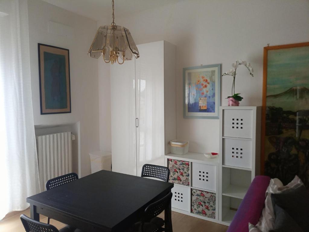 una sala da pranzo con tavolo e sedie neri di BOLOGNA QUARTIERE SAVENA - APPARTAMENTO DI STEFANO a Bologna