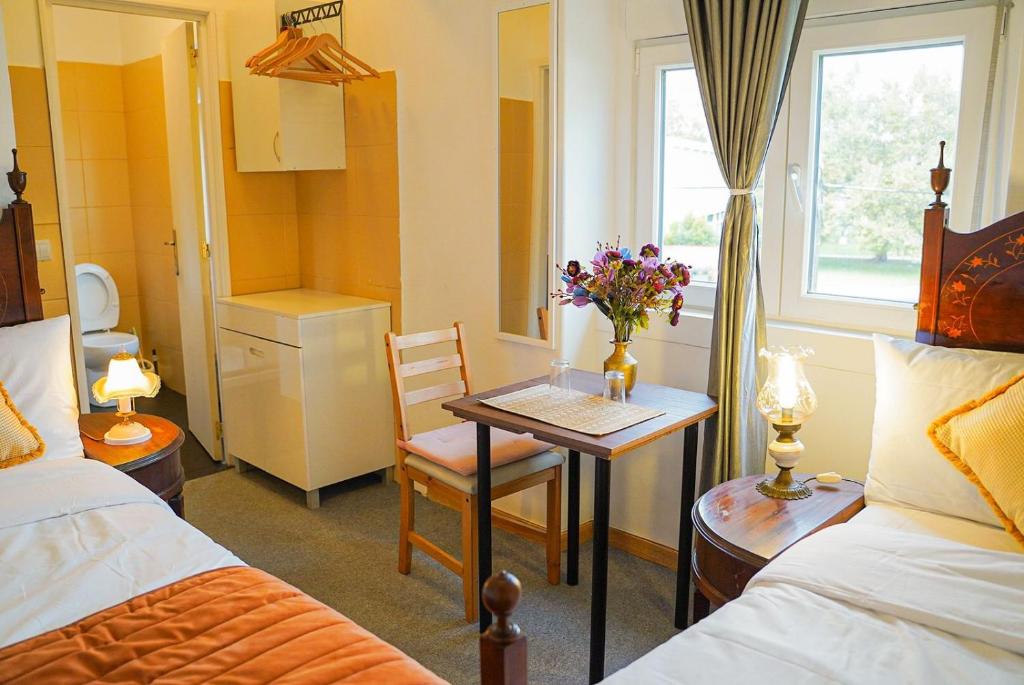 una camera d'albergo con un tavolo con fiori di Residencial Airside Palace a Lisbona