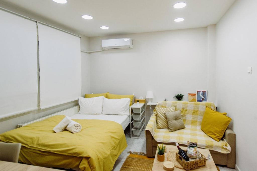mały pokój z 2 łóżkami i stołem w obiekcie Mellow Yellow w mieście Komotini