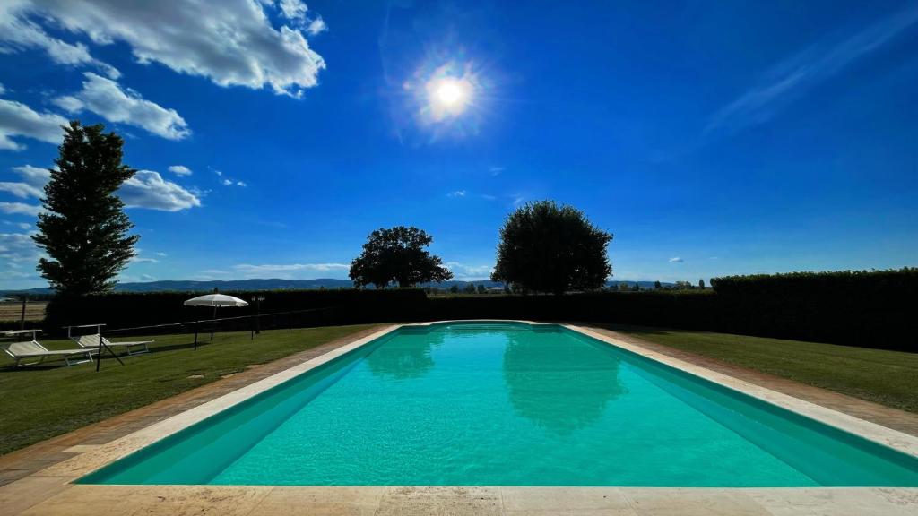 een zwembad in een tuin met een blauwe lucht bij Spello By The Pool - Sleeps 11 - wifi, air con, pool for your exclusive use in Limiti
