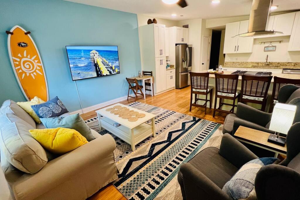 a living room with a surfboard on the wall at Luxury 2/2 private oasis w/Hot Tub walk to Beach in Cape Canaveral