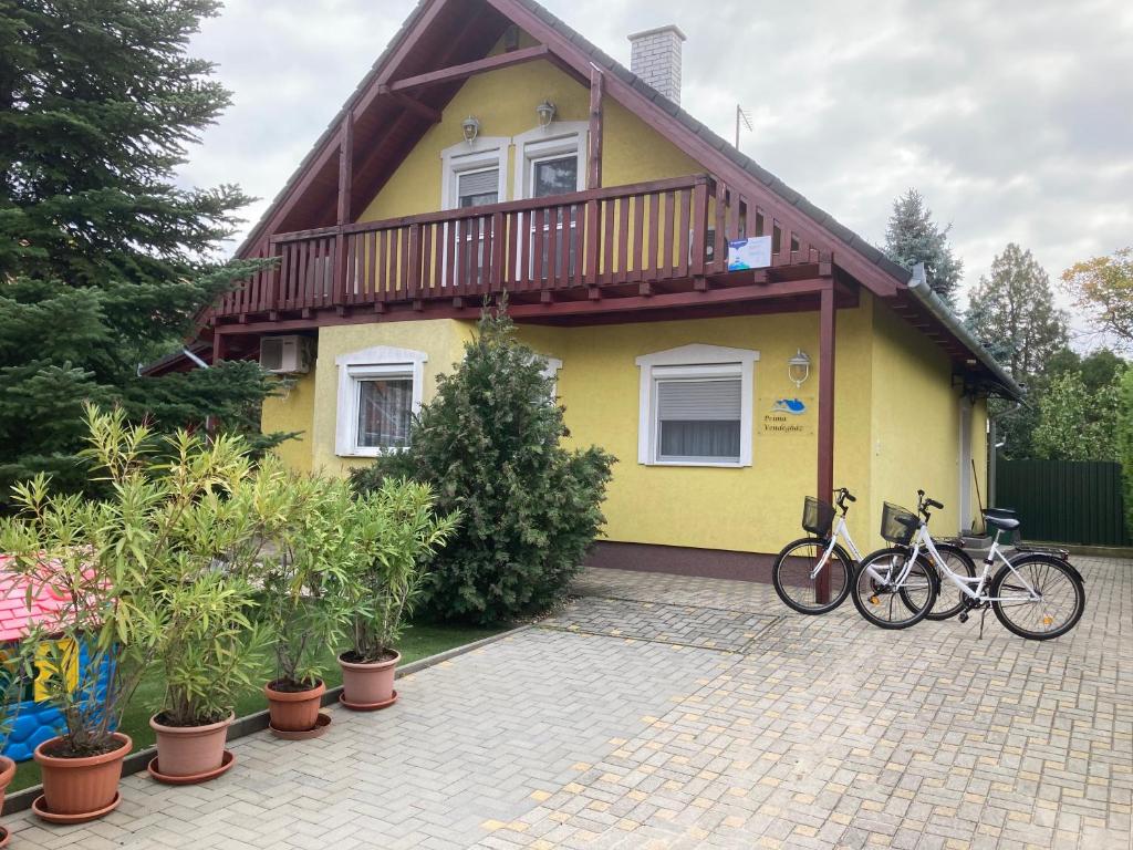 dos bicicletas estacionadas frente a una casa amarilla en Príma Vendégház, en Tiszakécske