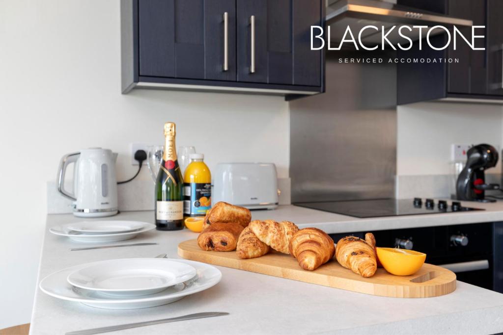 a kitchen counter with a cutting board with croissants and bread at Avery House 4 - One Bedroom with Outdoor Terrace in Darlington