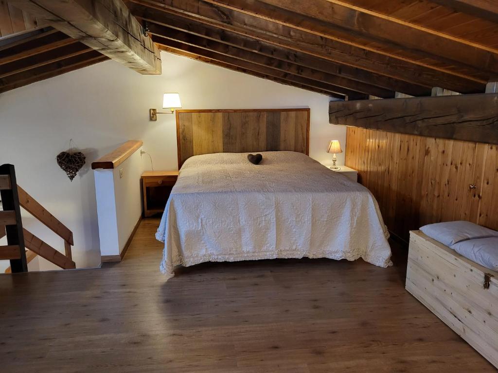 1 dormitorio con 1 cama en una habitación con suelo de madera en Mansarda Abetone, en Abetone