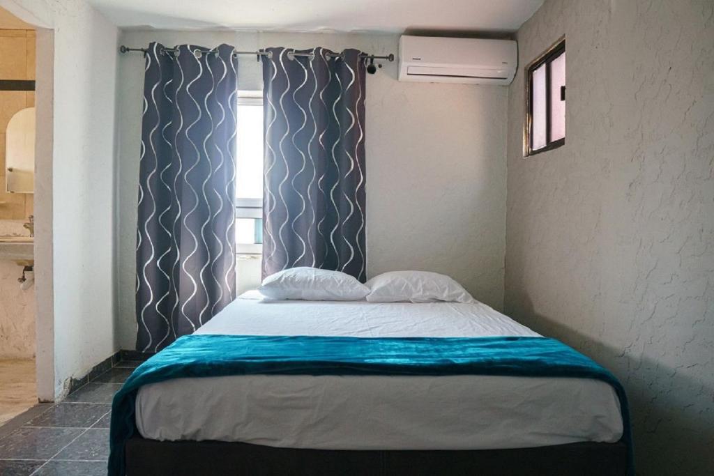 Cama en habitación pequeña con ventana en Access Blue Cristal, en Monterrey