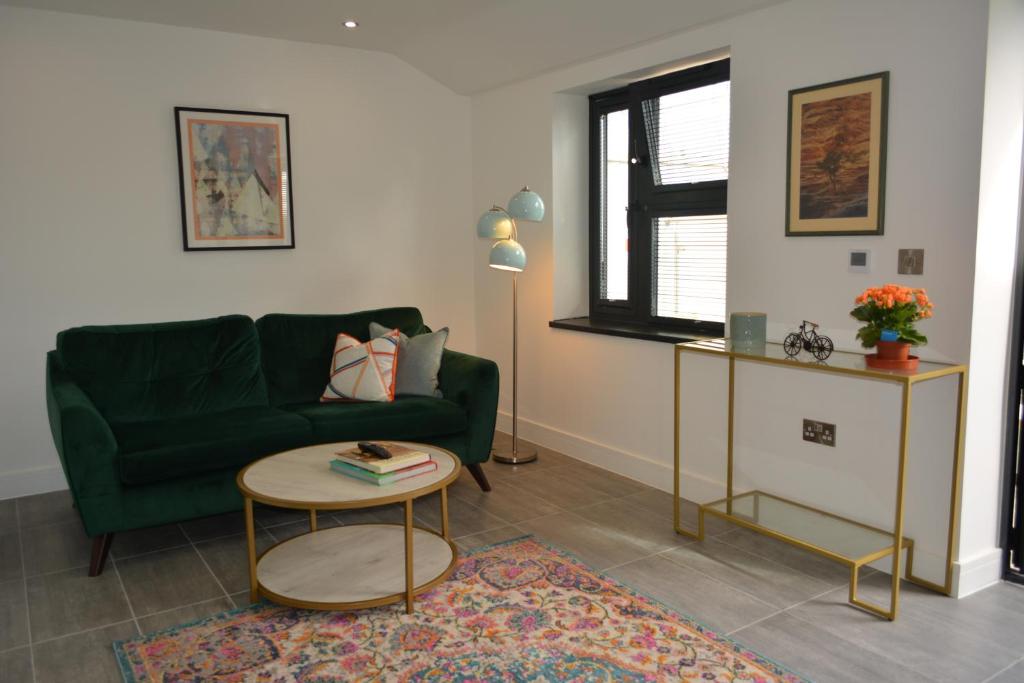 a living room with a green couch and a table at 8 Jarn Court in Oxford