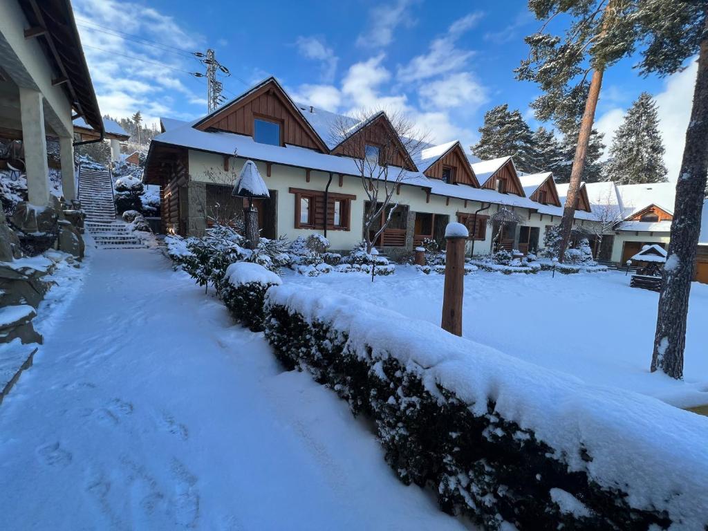 ein schneebedecktes Haus mit einem schneebedeckten Hof in der Unterkunft Slanický Dvor in Námestovo