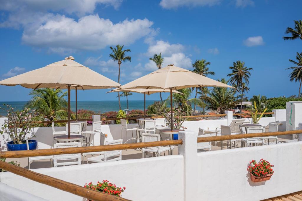 ein Restaurant mit Liegestühlen und Sonnenschirmen am Strand in der Unterkunft Pousada Chez Toi in Jericoacoara