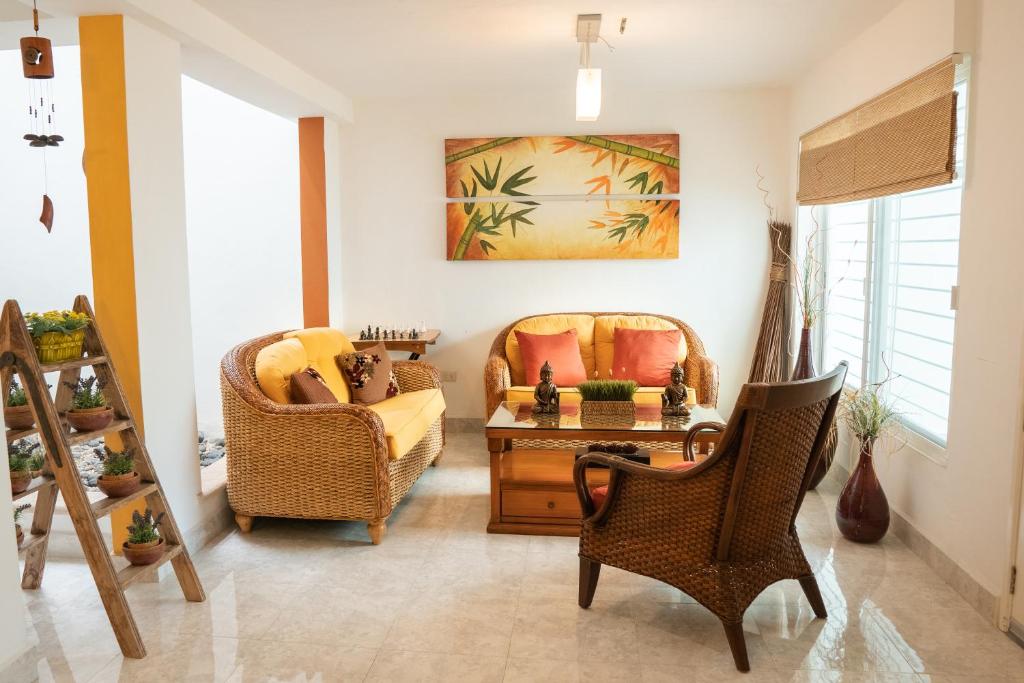 a living room with two chairs and a table at Casa Familiar para hospedaje privado en Mérida in Mérida