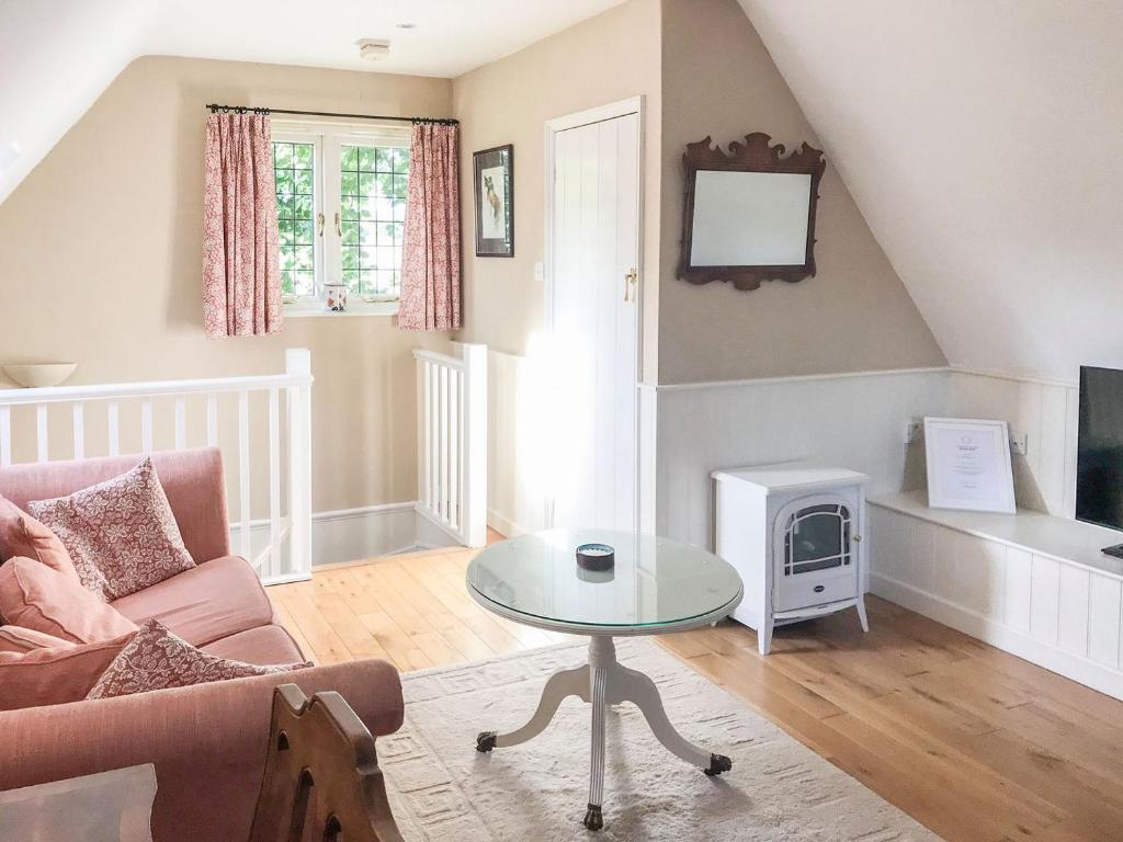 a living room with a couch and a table at Goodwood Coach House in Westhampnett