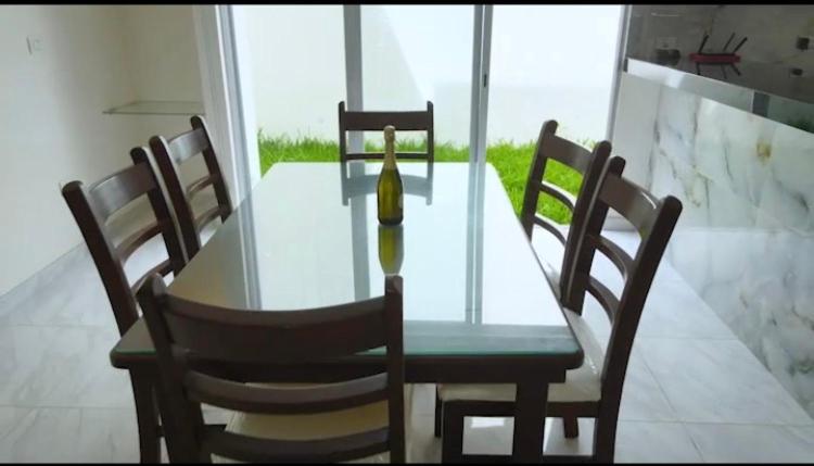 - une table en verre avec 4 chaises et une bouteille dans l'établissement linda vista, à El Castillo
