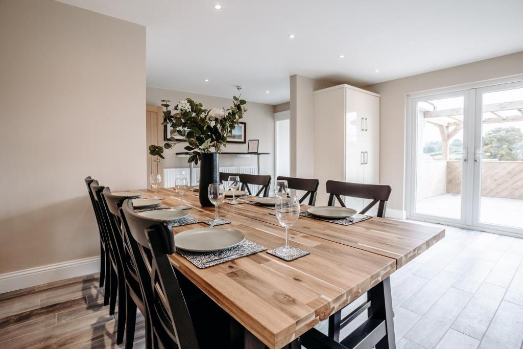 un comedor con una larga mesa de madera y sillas en Mountain View Lodge en Newcastle