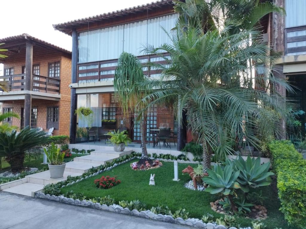 a courtyard with palm trees in front of a building at Casa de Campo Gravata-Pe in Gravatá