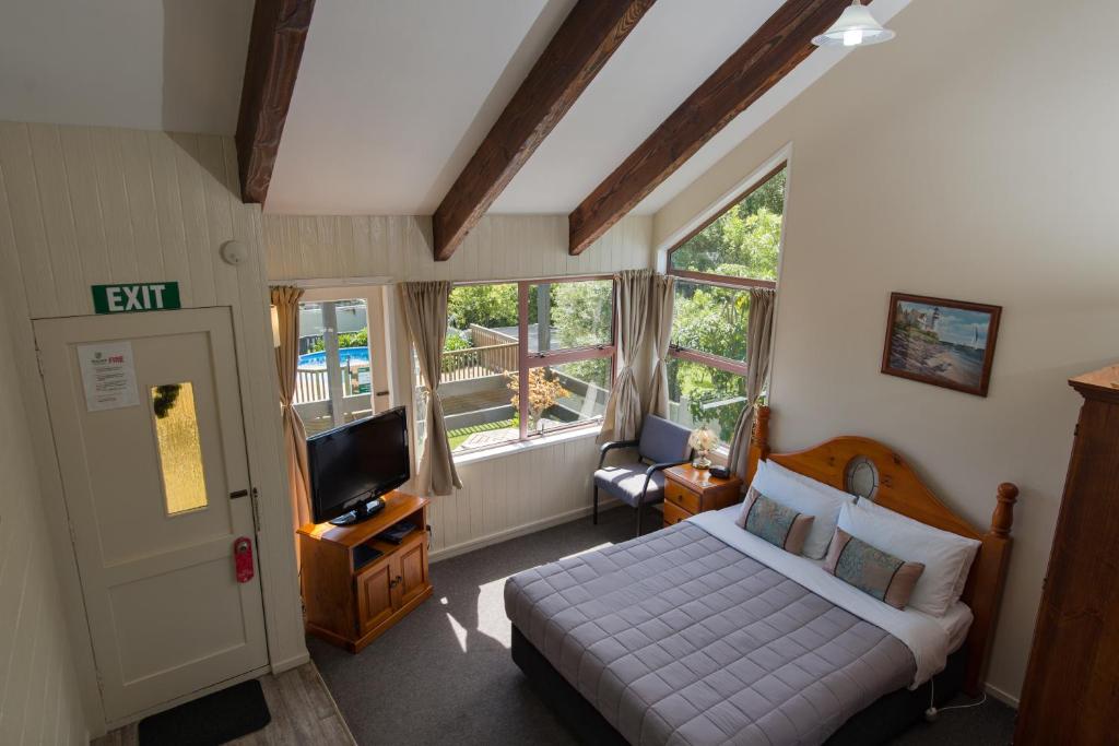 ein Schlafzimmer mit einem Bett und einem TV. in der Unterkunft Howick Motor Lodge in Auckland
