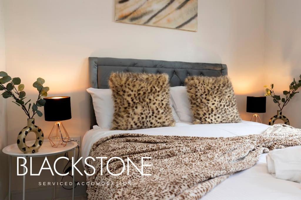 ein Schlafzimmer mit einem Bett mit Leopardenkissen und Lampen in der Unterkunft Avery House 8 - One Bed Apartment by BPNE in Darlington
