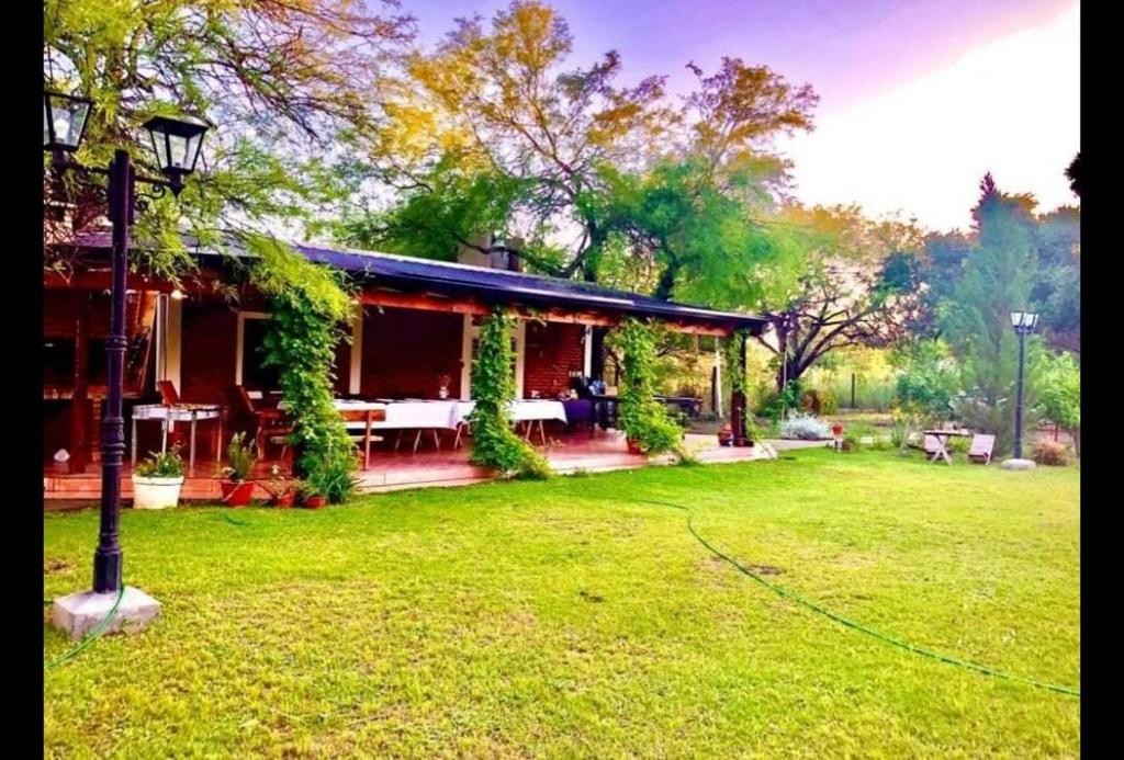 una casa con un cortile verde davanti di El Carmelo a Santiago del Estero