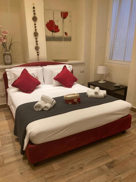 sypialnia z dużym łóżkiem z czerwonymi poduszkami w obiekcie Borgo20 Firenze we Florencji