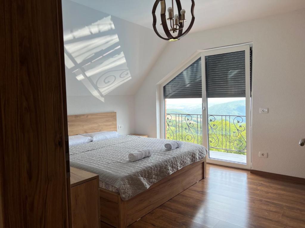 a bedroom with a bed and a large window at Villa Ozoni - Jezerc in Ferizaj
